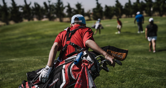 Golfer mit Golfbag geht über Golfplatz
