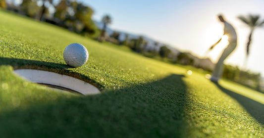 Golfer auf dem Green - Ball vor dem Loch